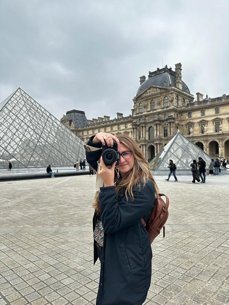 Alyson McClaran photographing at the Louvre in Paris, camera raised