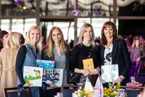 Four attendees holding books at ACE Scholarships Women's Luncheon Denver