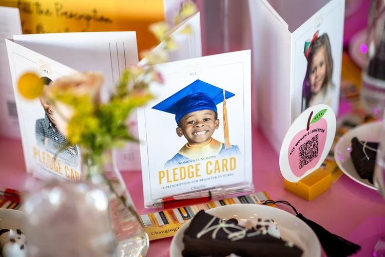 Pledge card table detail with student photos at ACE Scholarships fundraiser Denver Colorado
