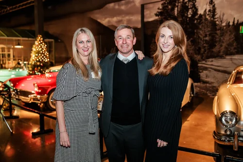 Guests posing with classic cars at corporate holiday party Vehicle Vault Parker Colorado